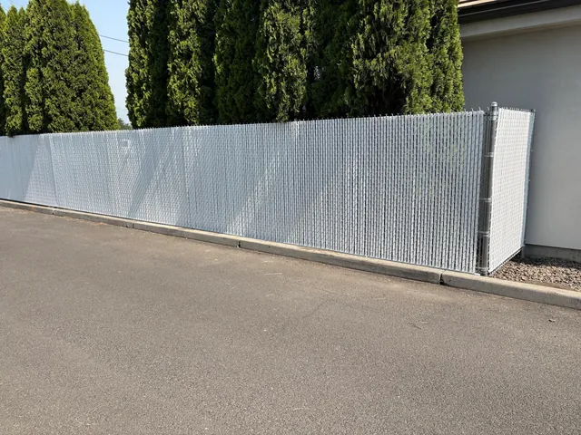 Finished galvanized chain-link fence fitted with light gray privacy slats
