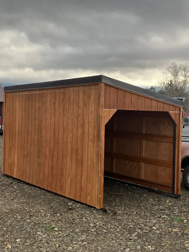 Wood-sided portable shelter built on a black metal frame with tow points